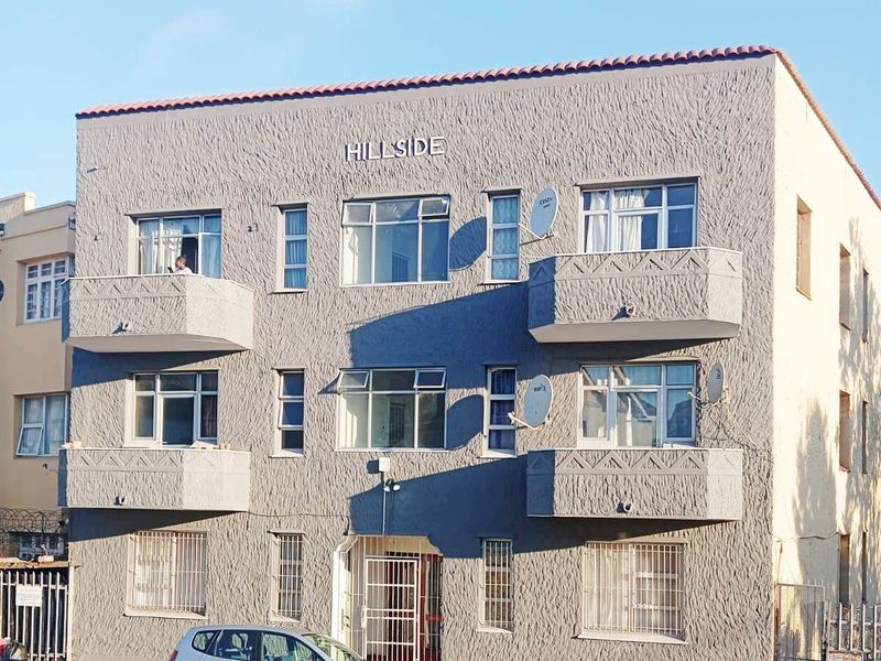 Front elevation of the Hillside apartment building featuring multiple balconies, security gates, and a textured facade finish.