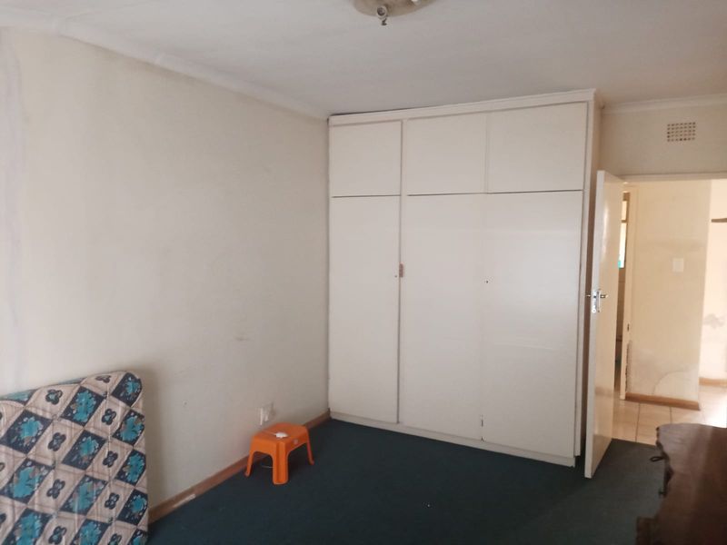 A bedroom featuring built-in cupboards and carpeted flooring, offering a blank canvas for potential updates and interior design improvements.