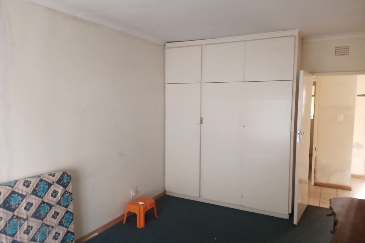 A bedroom featuring built-in cupboards and carpeted flooring, offering a blank canvas for potential updates and interior design improvements.