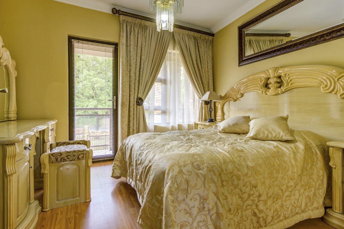 A bedroom featuring laminate flooring, a glass door providing outdoor access, and decorative coving.