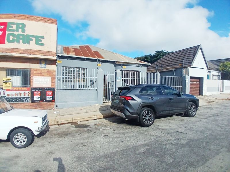 Front exterior view of the property featuring security fencing, security gates, and a corrugated metal roof.