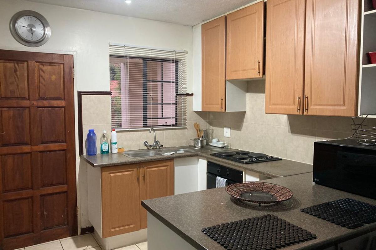 Functional kitchen featuring laminate cabinetry, built-in oven and hob, tiled backsplash, and tiled flooring, offering a practical layout for daily meal preparation.