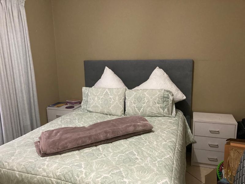 A standard bedroom featuring tiled flooring and neutral wall tones, providing a functional and comfortable sleeping space.