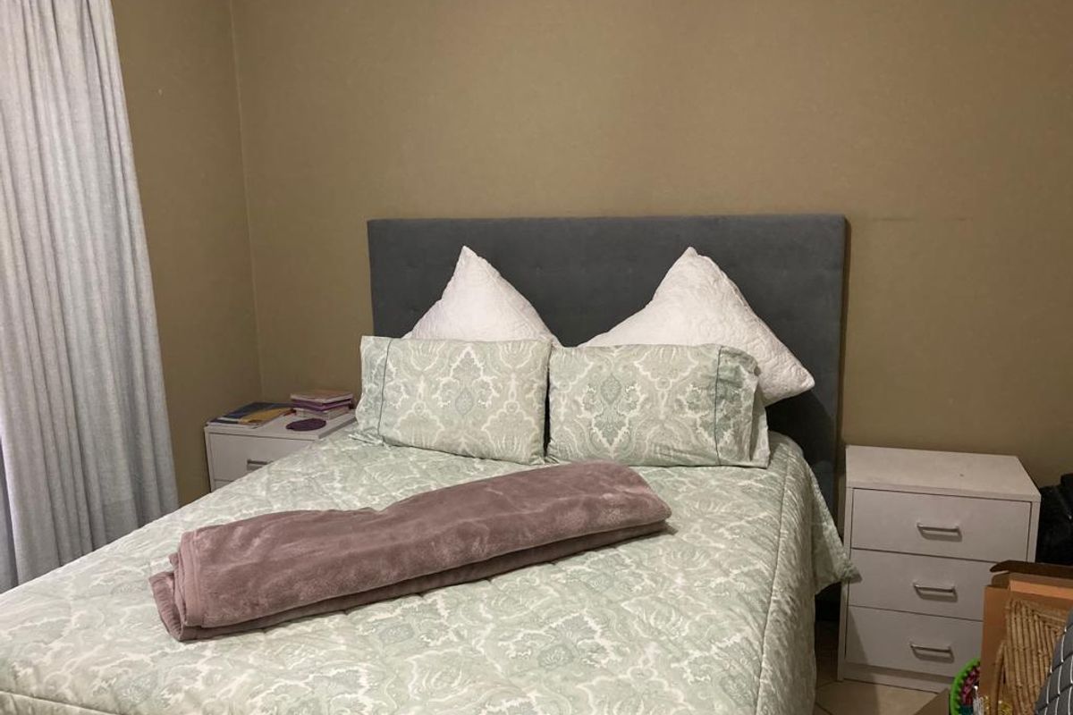 A standard bedroom featuring tiled flooring and neutral wall tones, providing a functional and comfortable sleeping space.