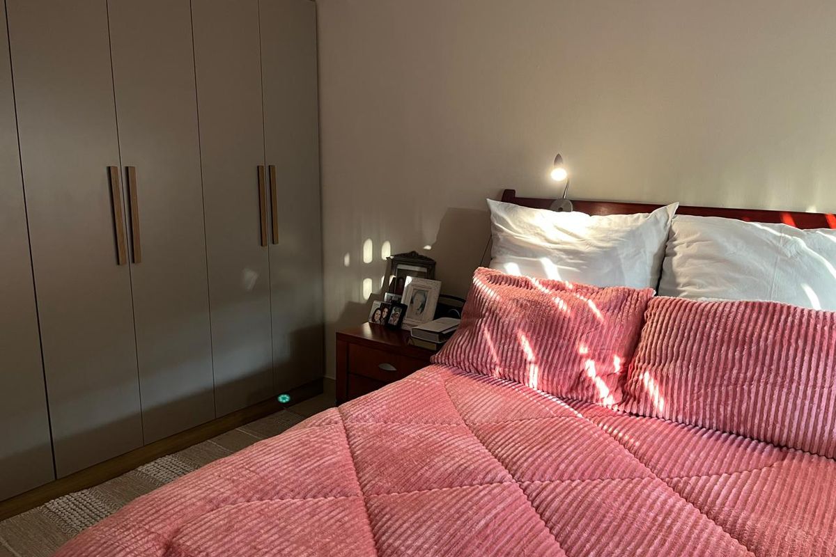 A cozy bedroom featuring a large built-in wardrobe with modern handles, providing ample storage space.
