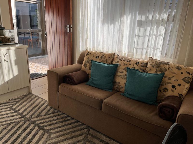 A living room area featuring tiled flooring, built-in cabinetry, and direct access to an outdoor patio through a sliding glass door.