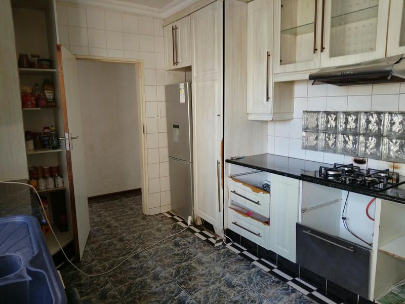Kitchen featuring built-in cabinetry, granite countertops, and a gas hob, currently requiring repairs to cabinet fronts and appliance integration.