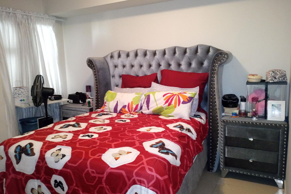 A bedroom featuring a bulkhead ceiling and curtain rails, providing a functional space for rest.
