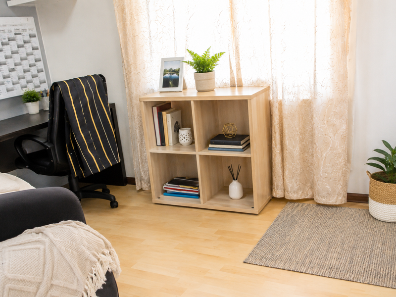 A functional home office space featuring light-toned laminate flooring and a built-in desk area, providing a clean and organized workspace.