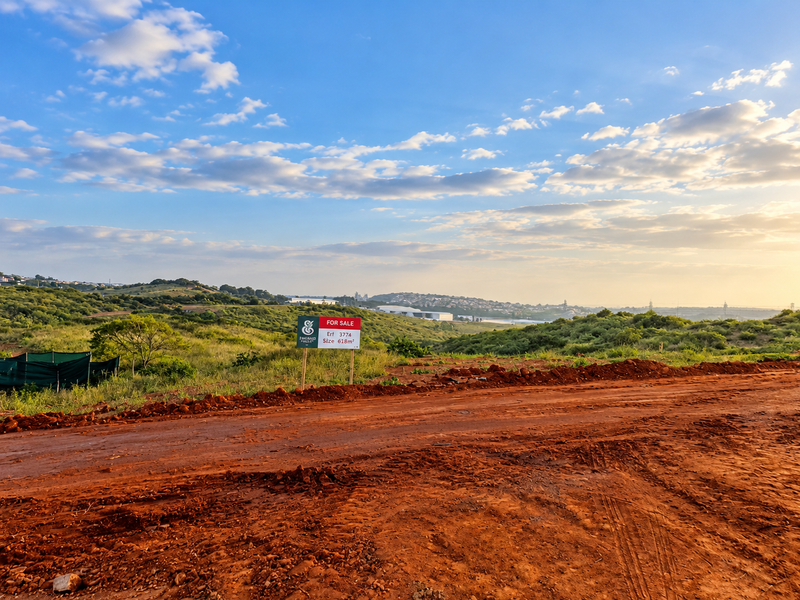 A vacant residential plot of 618 square meters featuring an unpaved access road and scenic landscape views.