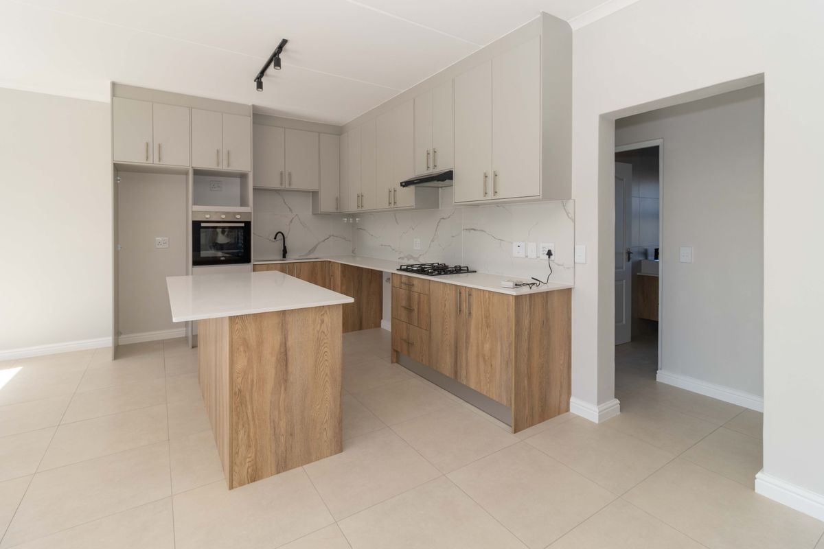 Modern kitchen featuring a central island, stone countertops, marble-look splashback, built-in oven, gas hob, and ample storage cabinetry with a neutral finish.