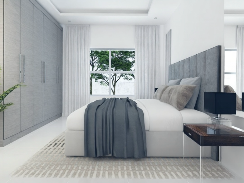 A modern bedroom featuring built-in cupboards, a recessed ceiling design, and large windows allowing natural light.