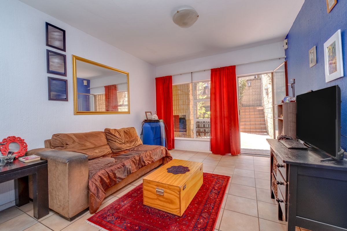 A living room featuring tiled flooring and a sliding glass door providing access to an outdoor area.