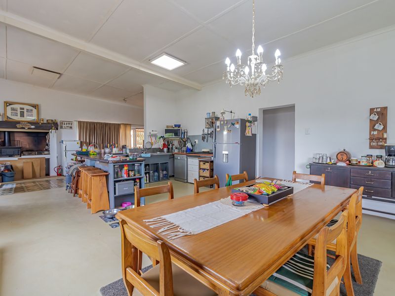 Spacious open-plan living and kitchen area featuring a built-in fireplace, central kitchen island, and functional cabinetry, offering a versatile layout for family living.