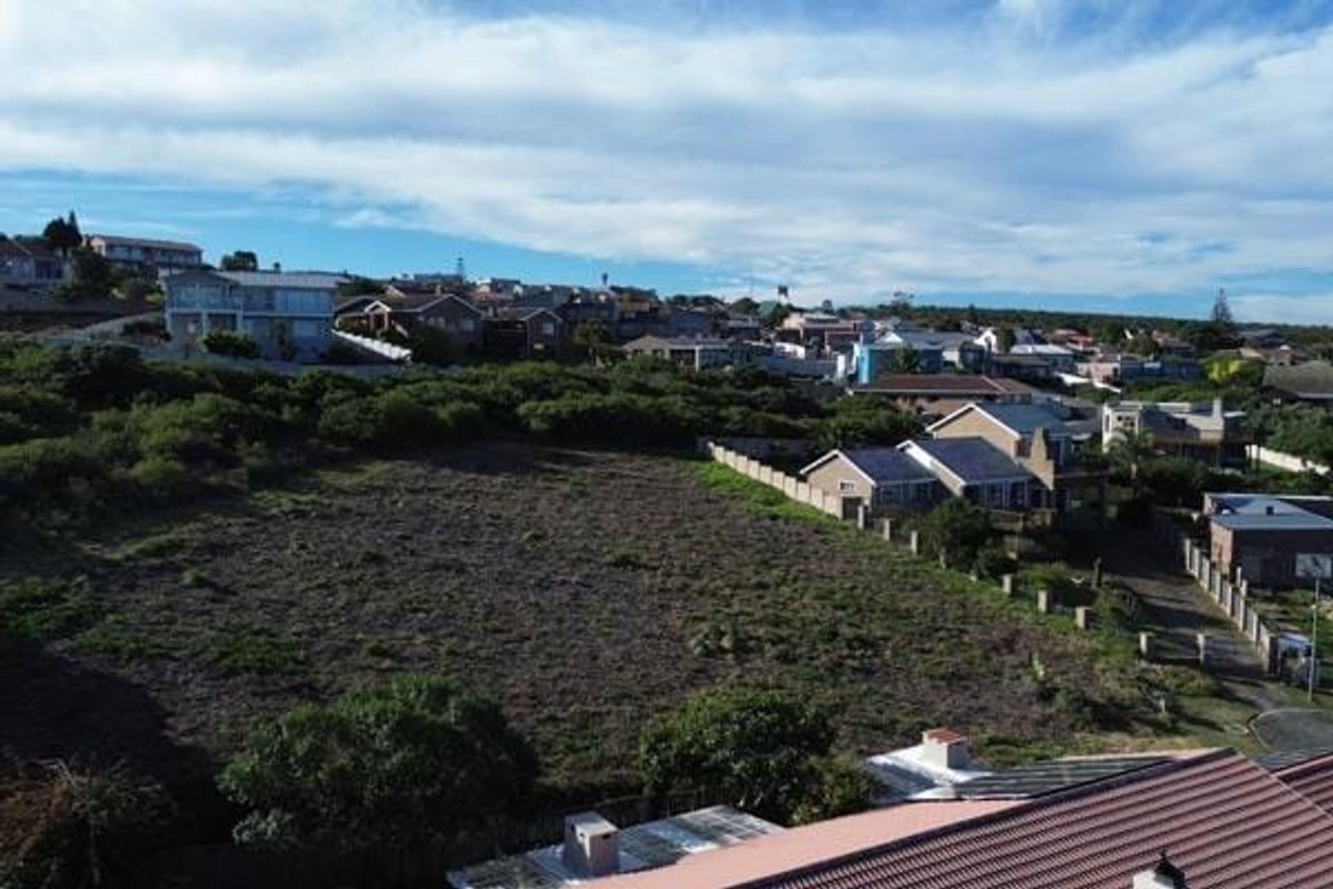 An aerial view of a vacant residential plot situated within an established neighborhood, showcasing the surrounding landscape and nearby residential properties.