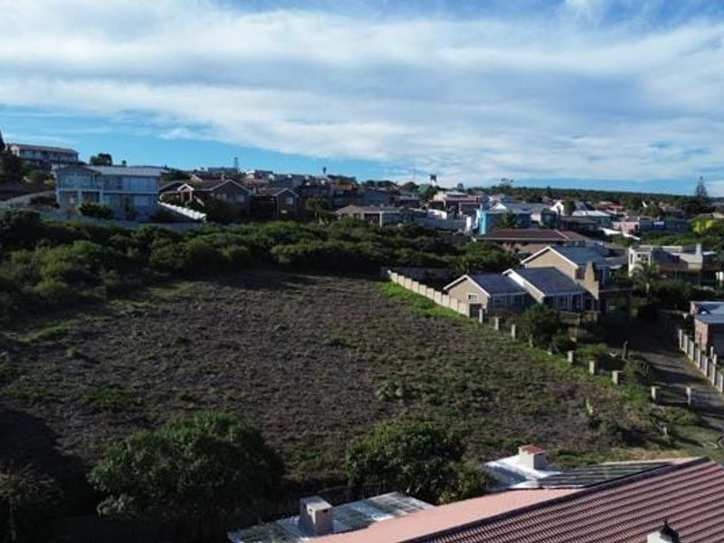 An aerial view of a vacant residential plot situated within an established neighborhood, showcasing the surrounding landscape and nearby residential properties.