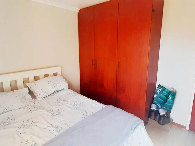 A bedroom featuring a built-in wooden wardrobe and coving detail.