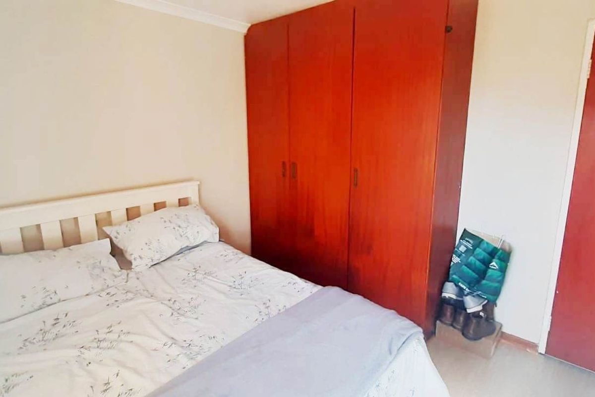 A bedroom featuring a built-in wooden wardrobe and coving detail.