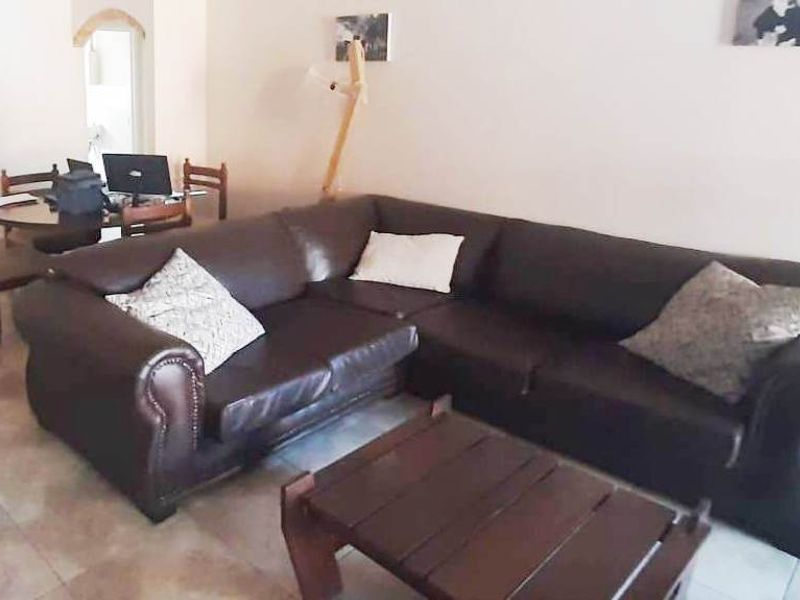 A living room area featuring tiled flooring and an open-plan layout, providing a functional space for relaxation and dining.
