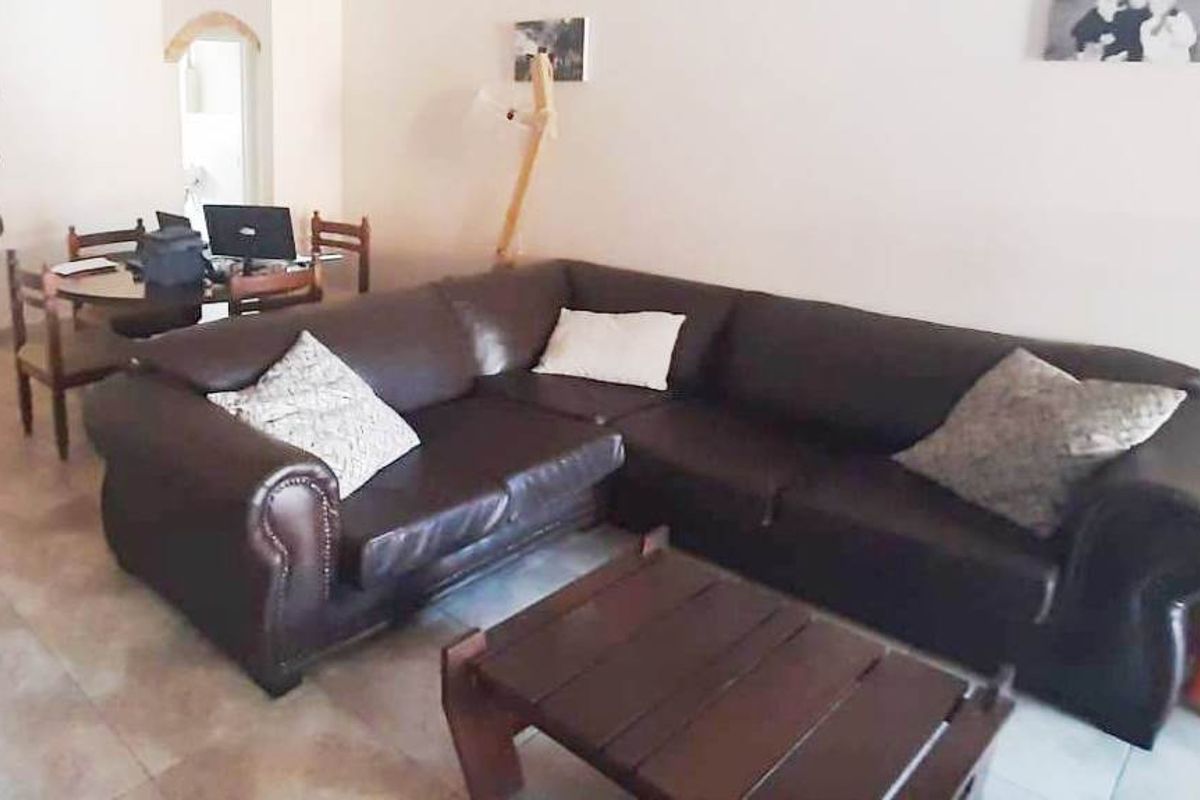 A living room area featuring tiled flooring and an open-plan layout, providing a functional space for relaxation and dining.
