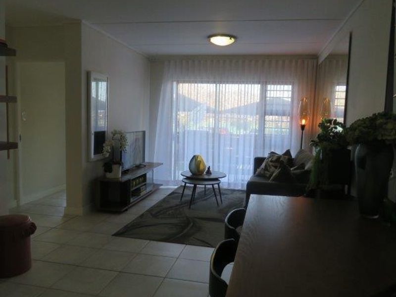 Open plan living and dining area featuring tiled flooring and a large sliding glass door providing access to the outdoor space.