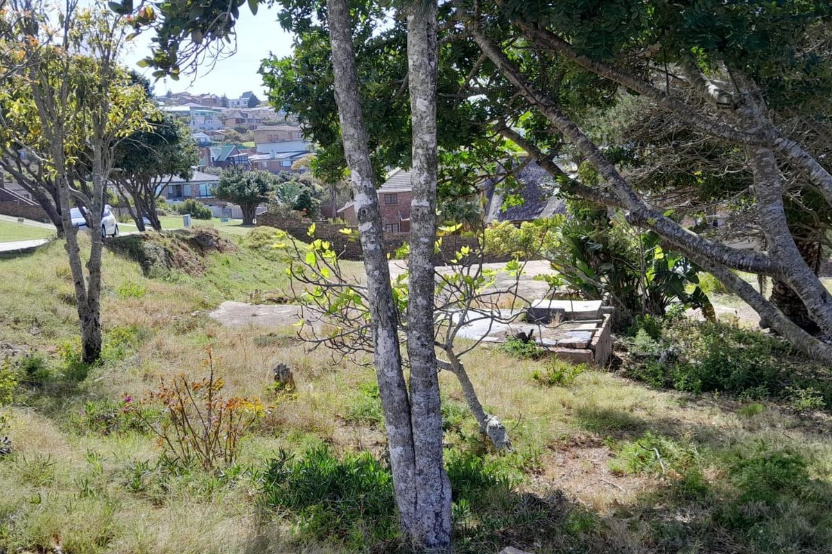 A view of a vacant residential plot featuring mature trees and an existing concrete slab foundation, set within a established neighborhood.