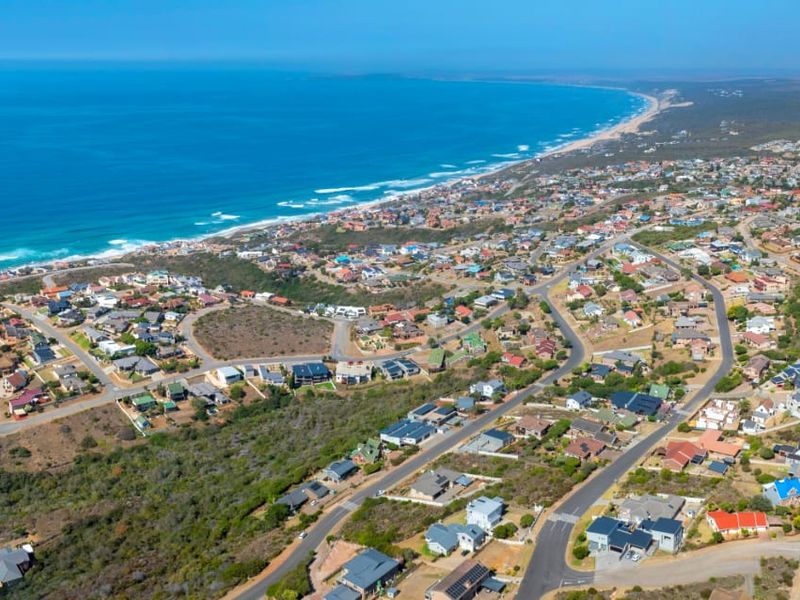 An expansive aerial view of a coastal residential neighborhood, showcasing the proximity to the ocean and surrounding natural landscape.