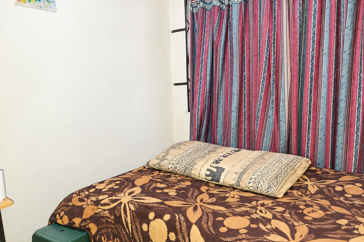 A bedroom space featuring a window with installed curtain rails and curtains.