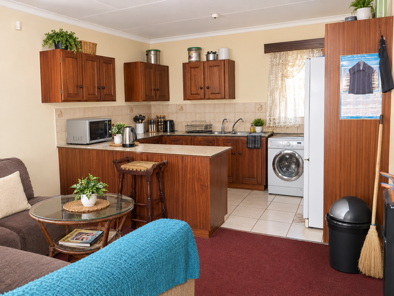 Open-plan kitchen featuring wooden cabinetry, tiled backsplash, and integrated laundry facilities, seamlessly connecting to the living area.