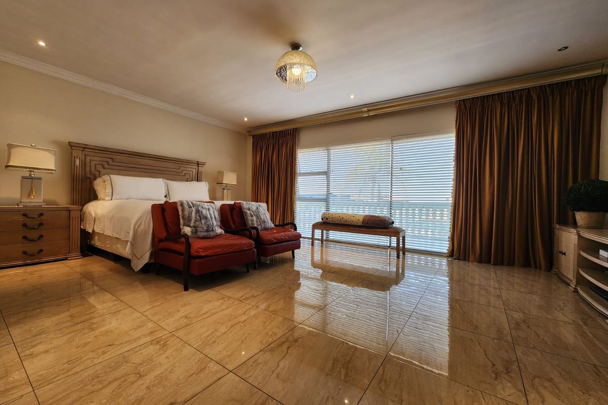 Spacious bedroom featuring polished tiled flooring, recessed lighting, and large sliding glass doors with integrated curtain tracks, offering a bright and well-maintained living space.