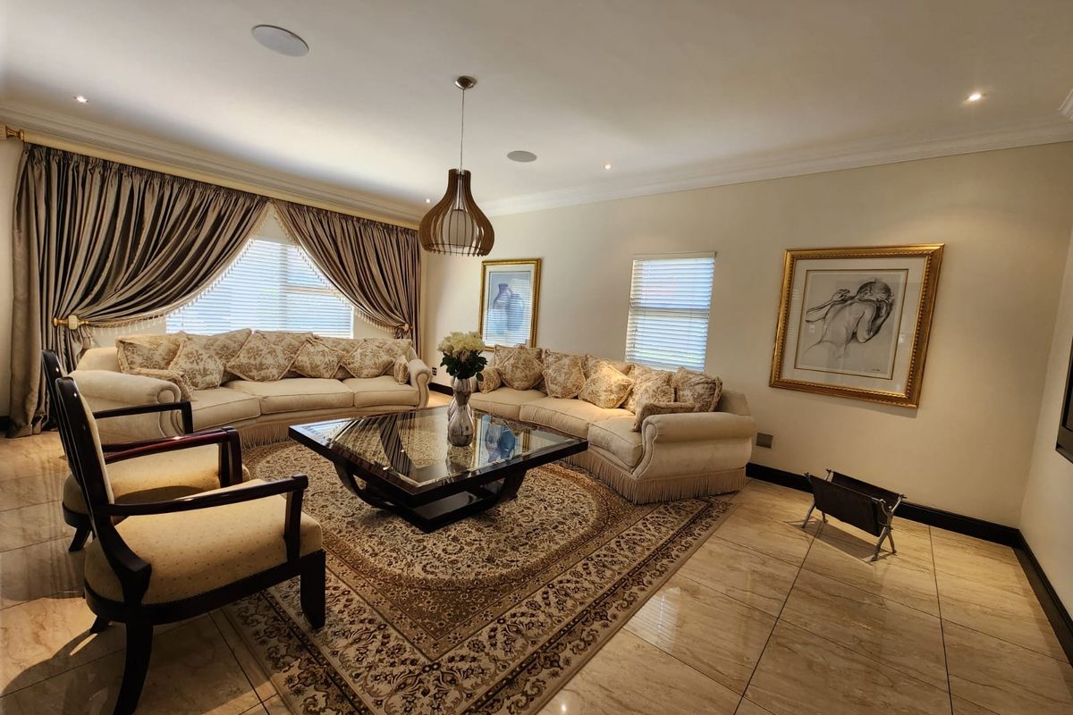 Spacious living room featuring polished tile flooring, recessed ceiling lighting, integrated ceiling speakers, and decorative cove cornicing.