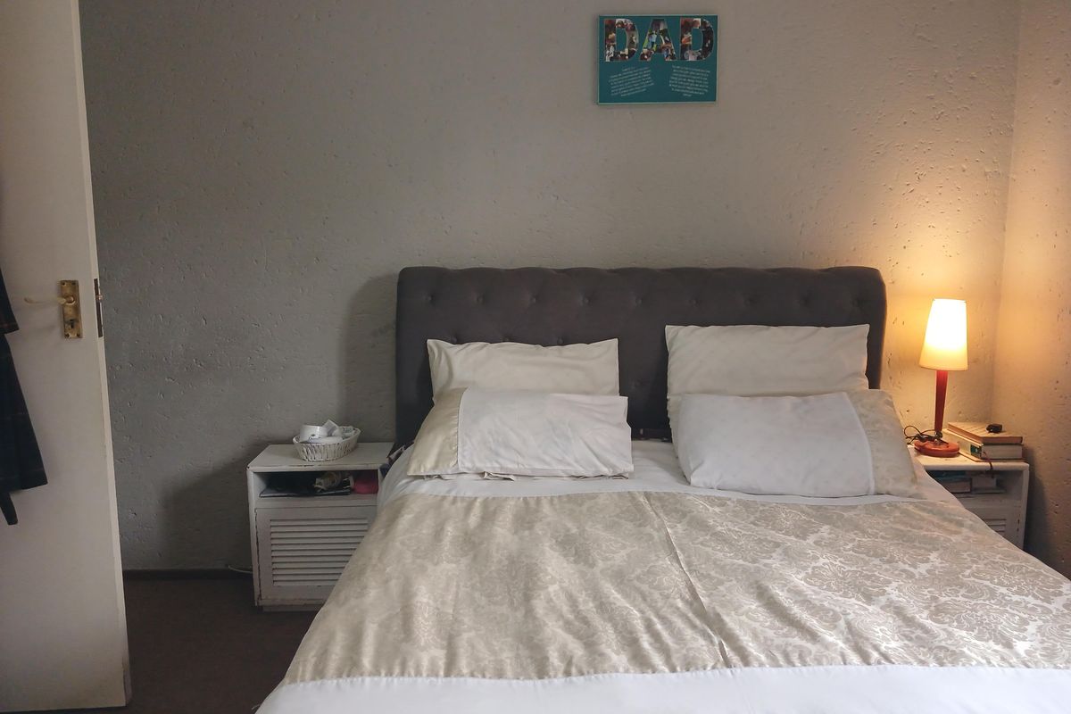 A standard bedroom featuring a neutral color palette, textured wall finish, and a functional layout suitable for a comfortable sleeping space.