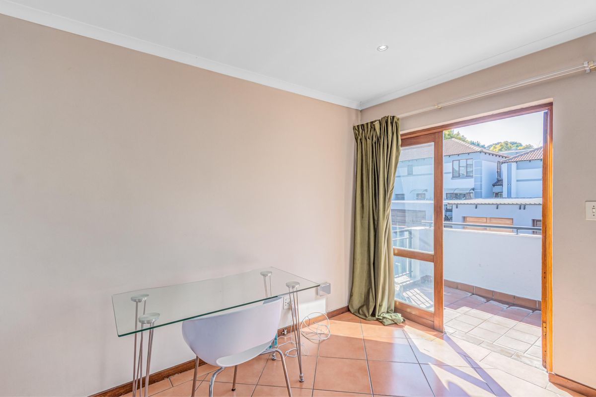 A bedroom featuring tiled flooring and a sliding glass door providing direct access to a private balcony.