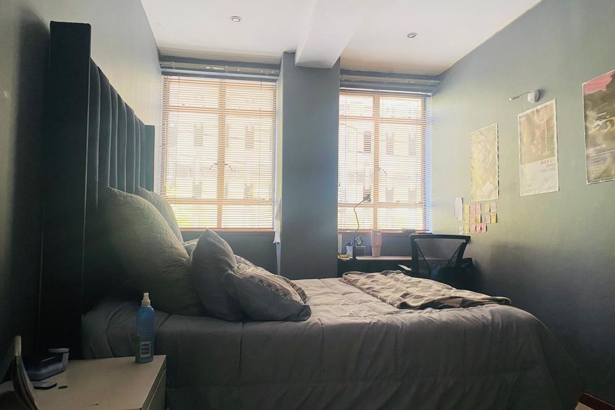 A bedroom featuring dual windows with fitted blinds, recessed ceiling lighting, and dark-toned wall finishes.
