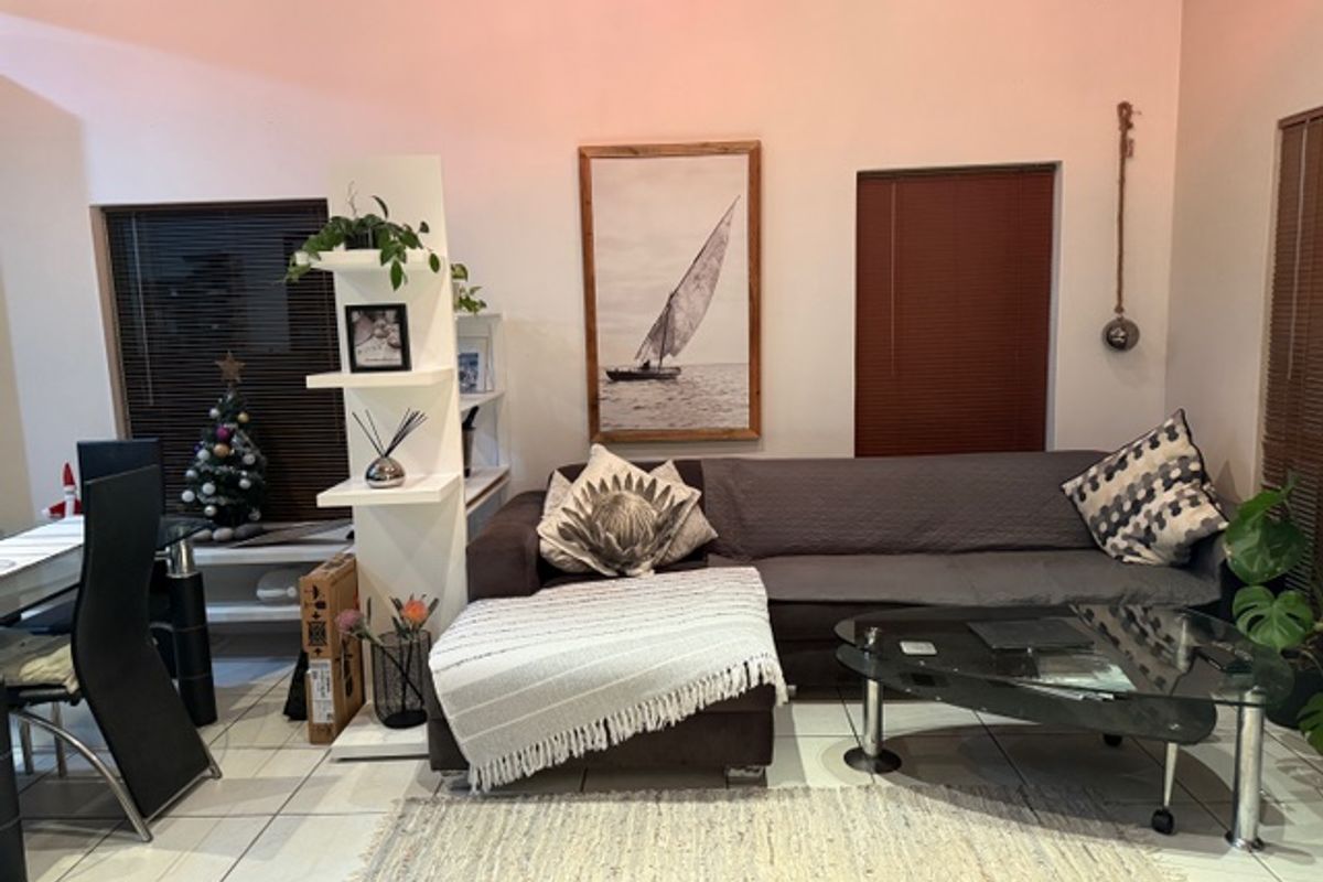 A comfortable living area featuring tiled flooring and window blinds, providing a functional space for relaxation and daily living.