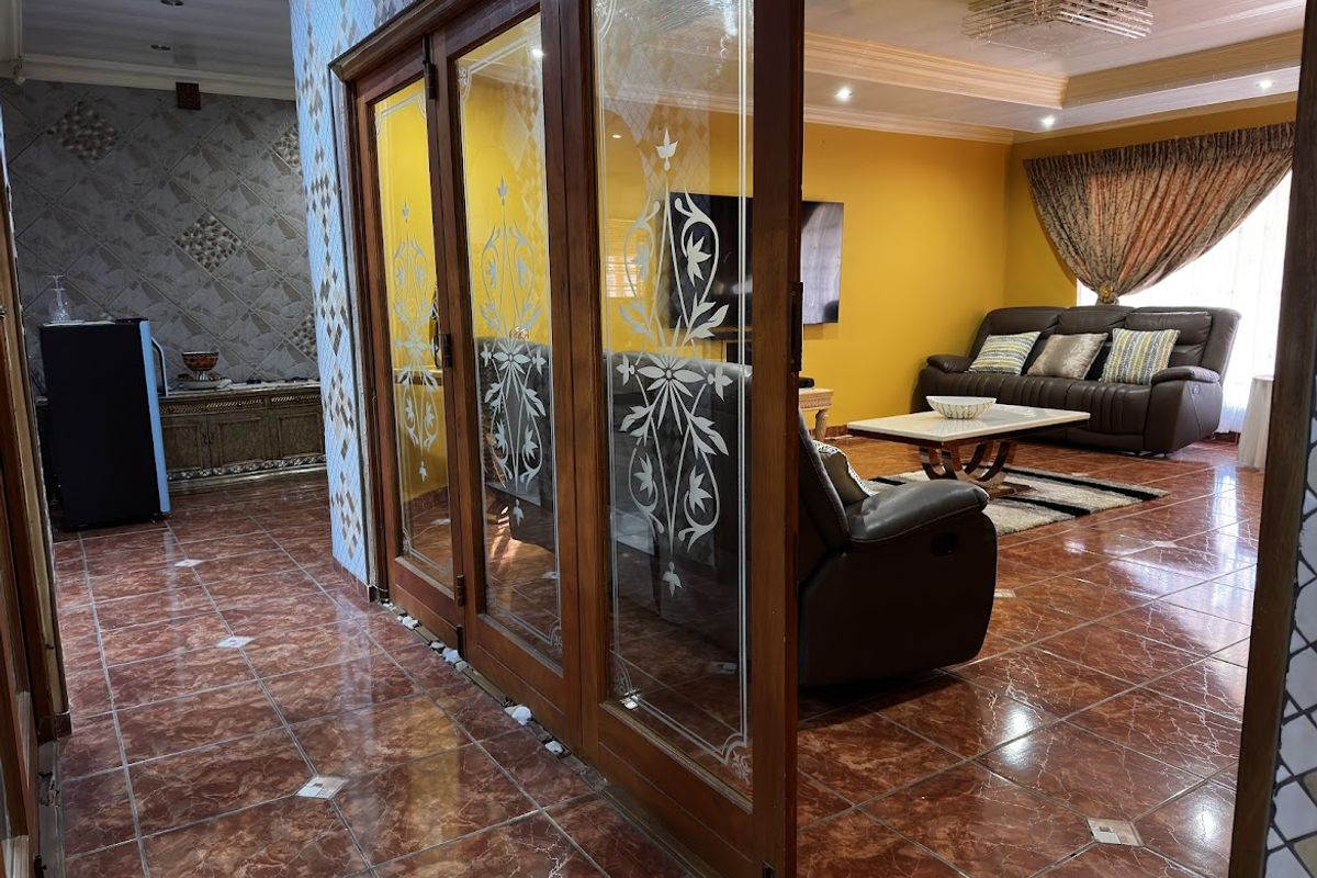 Spacious living area featuring decorative glass sliding doors, tiled flooring, and recessed ceiling lighting, creating a distinct separation between living and adjacent spaces.