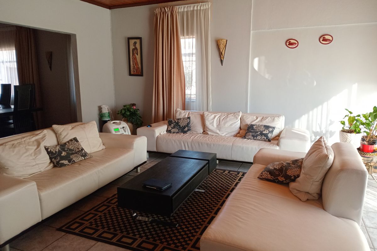A spacious living room featuring tiled flooring and a timber-paneled ceiling, offering a comfortable and functional area for relaxation.