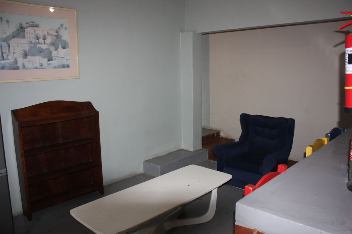 A multi-level interior space featuring a structural pillar, painted concrete flooring, and a built-in counter area.