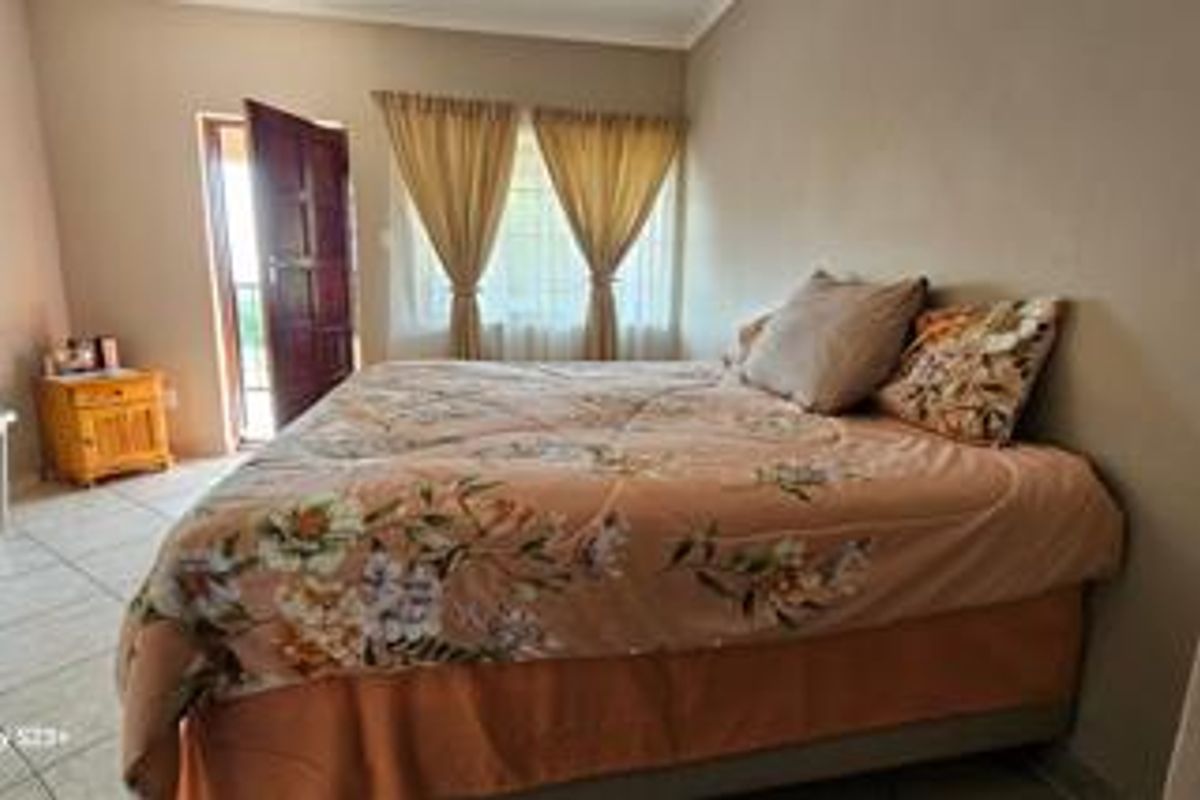 A bedroom featuring tiled flooring and a door providing direct access to an outdoor area.