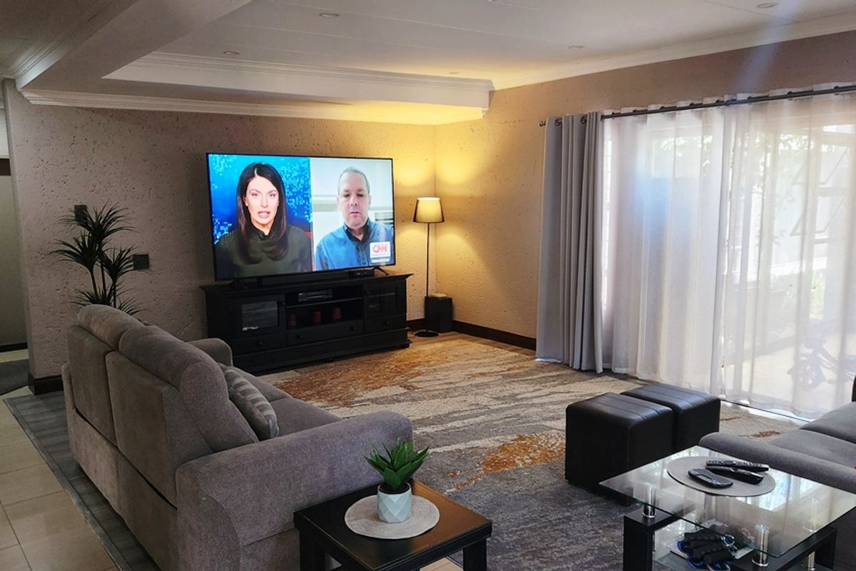 Spacious living room featuring recessed ceiling lighting, tiled flooring, and large sliding glass doors providing natural light and access to the exterior.