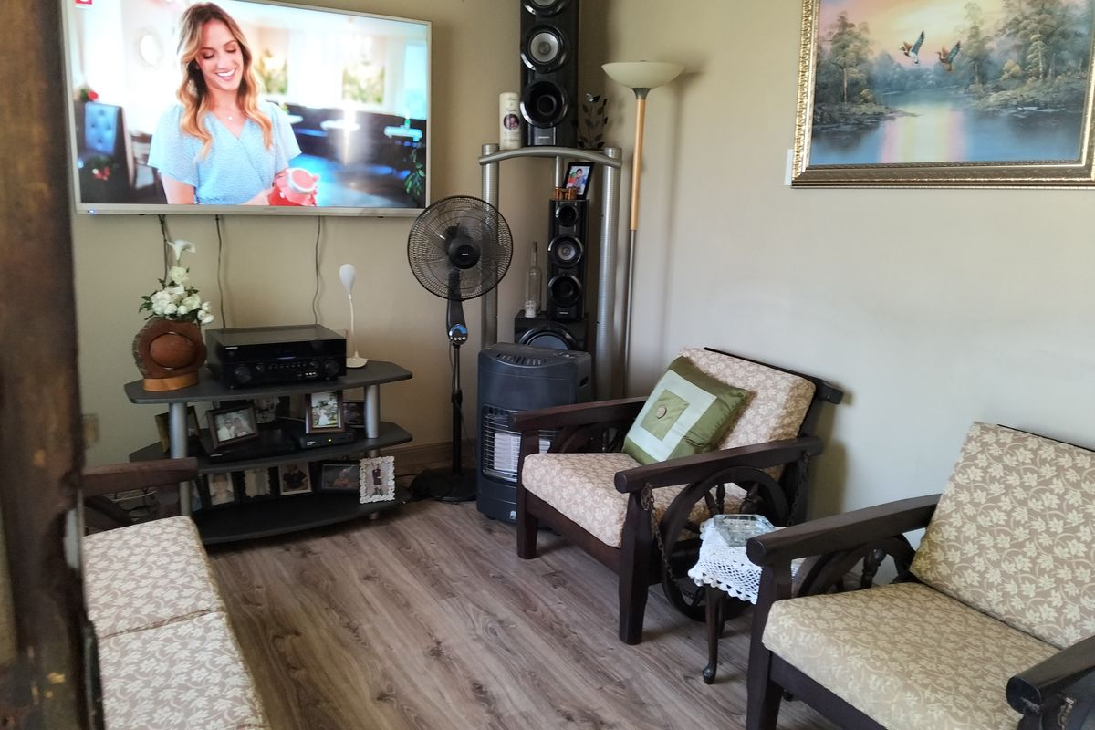 A cozy living room area featuring wood-look laminate flooring and neutral wall tones, providing a comfortable space for relaxation.