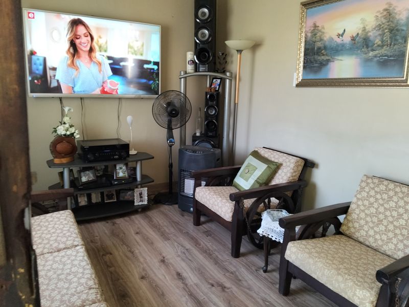 A cozy living room area featuring wood-look laminate flooring and neutral wall tones, providing a comfortable space for relaxation.