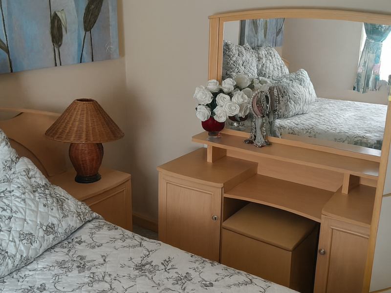 A cozy bedroom featuring neutral wall tones and a functional layout, providing a comfortable and well-maintained living space.