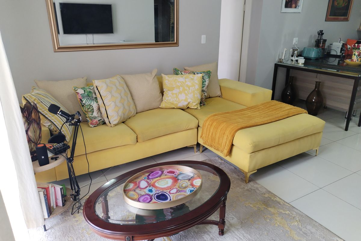 A bright living area featuring large format floor tiles and a neutral wall finish, creating a comfortable and well-maintained space.