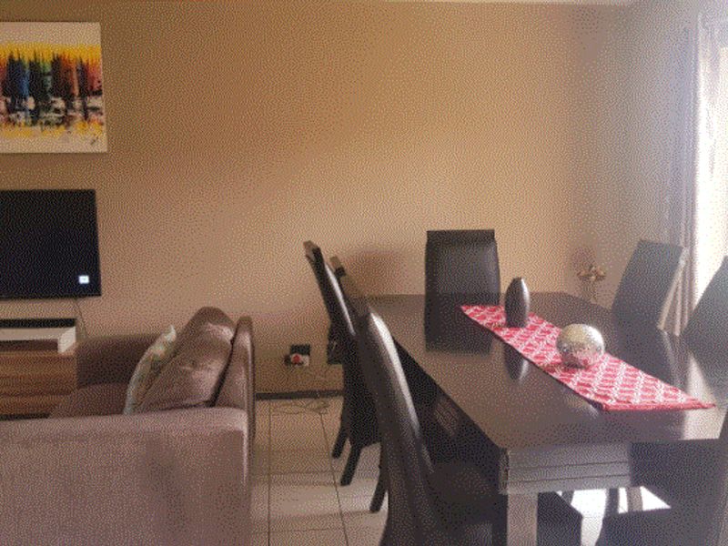 Open plan living and dining area featuring tiled flooring and neutral wall finishes, providing a functional space for daily living and entertaining.