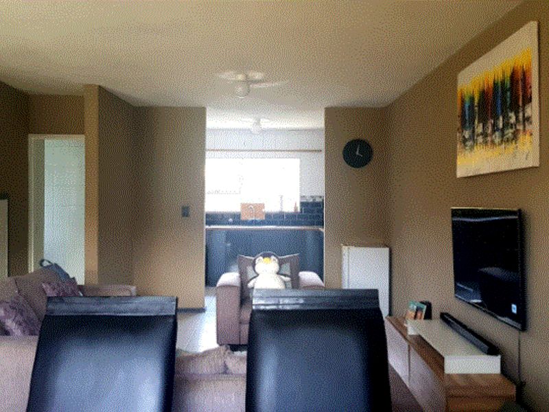 An open-plan living area featuring neutral wall tones and a view through to the kitchen space.