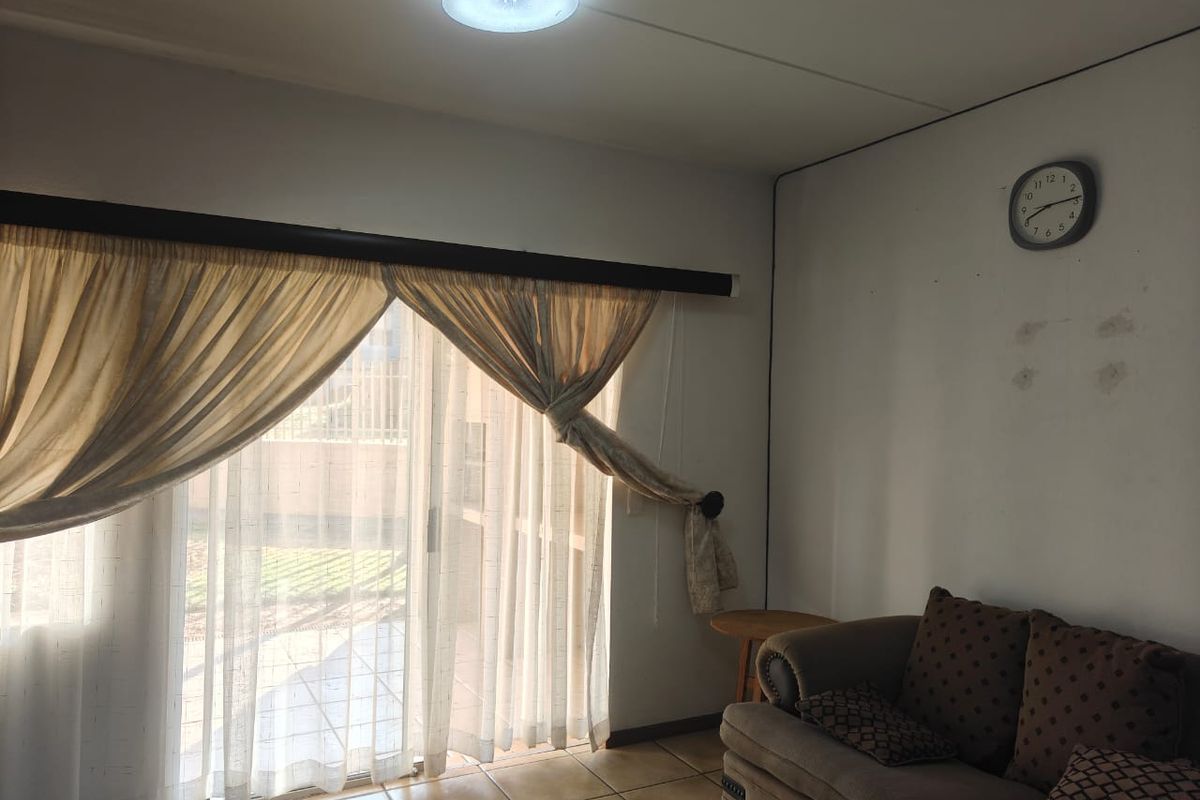 Living room featuring ceramic floor tiles and a large sliding glass door providing access to the exterior.