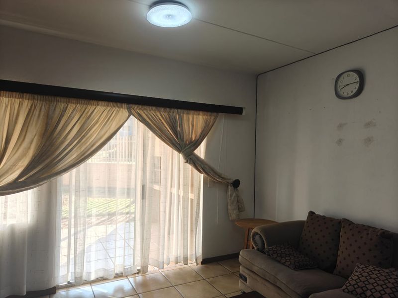 Living room featuring ceramic floor tiles and a large sliding glass door providing access to the exterior.