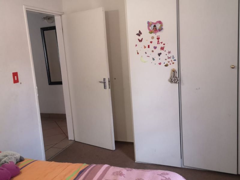 A bedroom featuring built-in cupboards and access to an adjoining hallway.