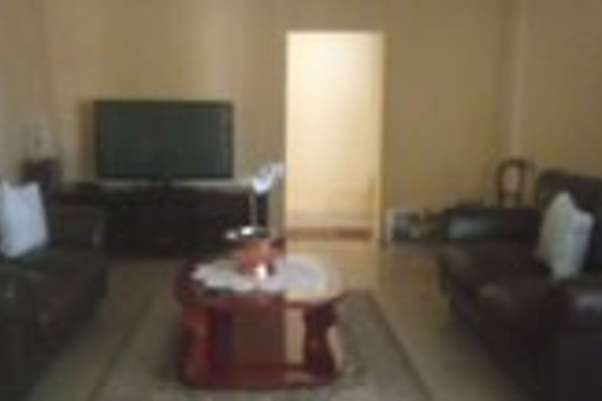 A living room area featuring tiled flooring and neutral wall finishes, providing a functional space for relaxation.